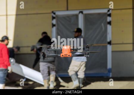 L'inspecteur contrôle le déversement de béton par les employés près de la maison nouvellement construite avec l'aide de drone sur le chantier de construction Banque D'Images