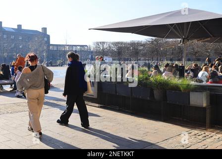 Profitez de températures chaudes pendant les vacances de mi-mandat du 2023 février sur Granary Square à Kings Cross, au nord de Londres, au Royaume-Uni Banque D'Images