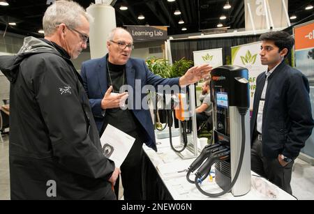 Vancouver, Canada. 16th févr. 2023. Un visiteur (L) regarde les appareils de chargement de voitures électriques au salon BUILDEX à Vancouver (Colombie-Britannique), Canada, le 16 février 2023. Environ 300 exposants du monde entier ont présenté leurs derniers produits et technologies lors de cette convention et salon professionnel pour l'industrie du bâtiment. Credit: Liang Sen/Xinhua/Alay Live News Banque D'Images