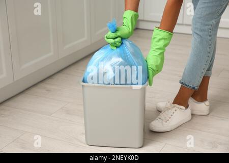 Femme prenant le sac à ordures hors de la poubelle à la maison, gros plan Banque D'Images