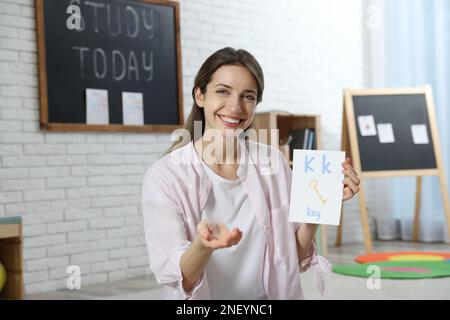 Bonne enseignante d'anglais féminine donnant la leçon à l'école primaire Banque D'Images