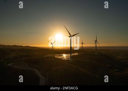 Vue aérienne du groupe d'éoliennes sur la côte au coucher du soleil. Centrale éolienne. Philippines. Banque D'Images