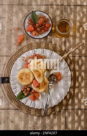 fromage cottage avec framboises et raisins de corinthe. les cheesecakes sont empilés et décorés de baies, un cheesecake dans une section Banque D'Images