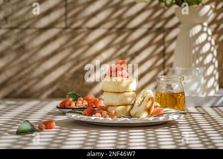 fromage cottage avec framboises et raisins de corinthe. les cheesecakes sont empilés et décorés de baies, un cheesecake dans une section Banque D'Images