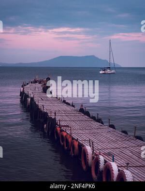 La vieille jetée de pêche en bois va dans la mer au coucher du soleil au printemps. Ville touristique Novyi Svet, Crimée Banque D'Images