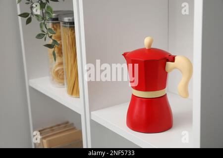 Cafetière geyser et articles d'épicerie sur l'étagère de la cuisine Banque D'Images