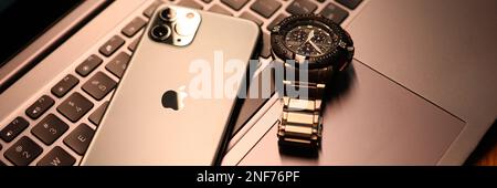 Tbilissi, Géorgie - 26 juillet 2022: Montre moderne de pomme de smartphone sur clavier d'ordinateur portable. Banque D'Images