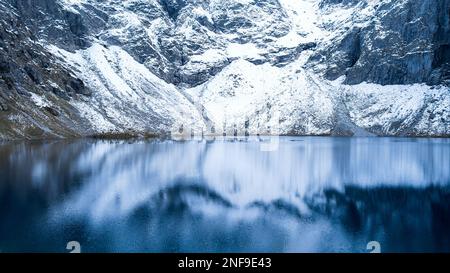 Czarny Staw Pod Rysamy ou lac Black Pond près de la cabane de montagne Morskie Oko Snowy dans les montagnes polonaises de Tatry, vue sur les drones, Zakopane, Pologne. Vue aérienne prise de magnifiques collines verdoyantes et montagnes dans des nuages sombres et reflet sur le lac Morskie Oko. Destination touristique de voyage Banque D'Images