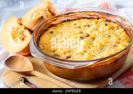 Bouillie de riz et de millet doux cuit au four avec citrouille et raisins secs dans une poêle en verre Banque D'Images