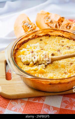 Bouillie de riz et de millet doux cuit au four avec citrouille et raisins secs dans une poêle en verre Banque D'Images