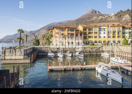 Cannero, Italie - 02-05-2023: Le beau petit port de Cannero avec des bateaux et des maisons qui réfléchit sur l'eau bleue Banque D'Images