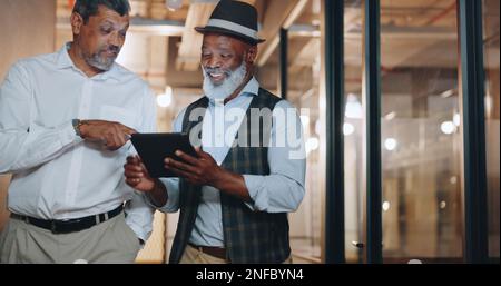 Partenariat, tablette et hommes d'affaires en déplacement au bureau analyser, parler et planifier un projet. Technologie, professionnel et homme senior Banque D'Images