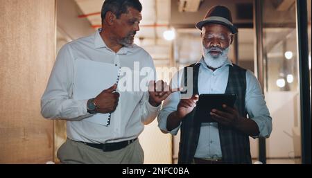 Partenariat, tablette et hommes d'affaires en déplacement au bureau analyser, parler et planifier un projet. Technologie, professionnel et homme senior Banque D'Images