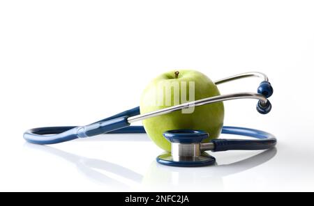 Le fond Apple représentant la santé et le stéthoscope autour réfléchi sur la table blanche et le fond blanc isolé. Vue avant. Banque D'Images