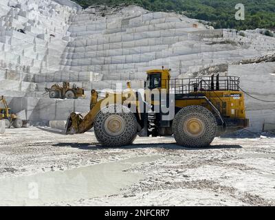 Chargeuse sur pneus travaillant dans une immense carrière de marbre en Europe. Transport des blocs de marbre. Banque D'Images