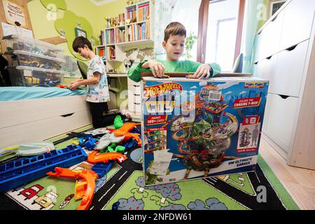 Ternopil, Ukraine - février, 2023: Les enfants unboxing Hot Wheels City Ultimate garage, jouer dans la chambre des enfants. Banque D'Images