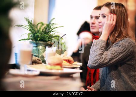 Heureux couple eating fast food burger et döner dans fast food cafe Banque D'Images