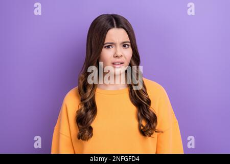 Photo de femme nerveuse fille porter orange vêtements tendance suspect regarder caméra en désaccord opinion sociale isolée sur fond violet couleur Banque D'Images