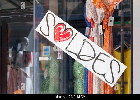 Panneau blanc dans une boutique de fenêtres disant en français "Soldes", signifiant en anglais "Sales". Banque D'Images