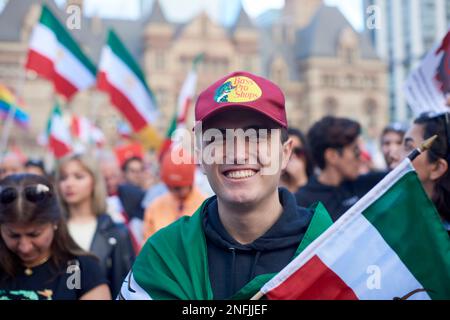 Toronto Ontario, Canada- 5 novembre 2022 : un homme drapé dans l'iranien sourit lors de la protestation le gouvernement iranien à l'hôtel de ville de Toronto/ Banque D'Images