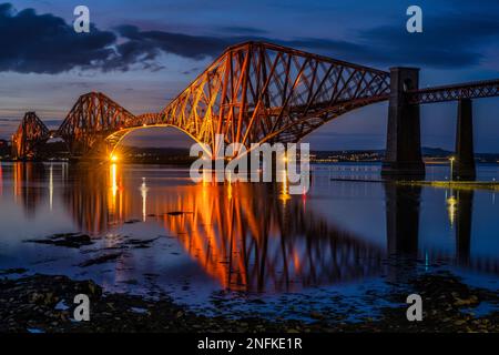 Le Forth Rail Bridge a été éclairé au crépuscule, avec Haws Pier en premier plan, depuis South Queensferry, Écosse, Royaume-Uni Banque D'Images