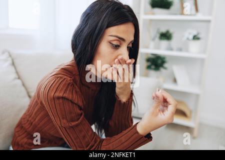 Une femme regarde malheureusement un anneau de mariage dans sa main, le divorce et la perte d'un partenaire, la rupture Banque D'Images