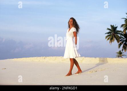Maldives. Jeune femme debout sur la plage tropicale. Banque D'Images