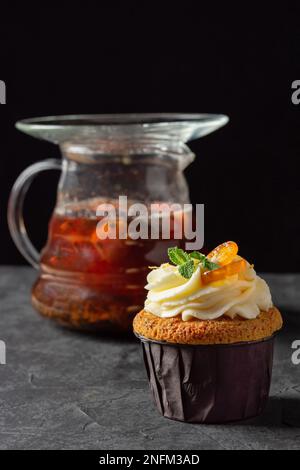 Cupcakes à la crème au fromage, décorés de baies sucrées sur fond sombre Banque D'Images