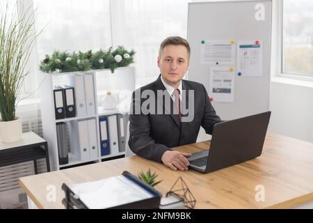 Homme au bureau. Employé de bureau dans le bureau avec décoration de Noël Banque D'Images