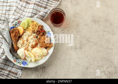 Nasi Uduk, riz de petit déjeuner indonésien avec divers accompagnement. Ayam Goreng, Bihun, Balado Egg, Kerupuk et Slice Cucumber. Vue de dessus avec espace de copie pour Banque D'Images