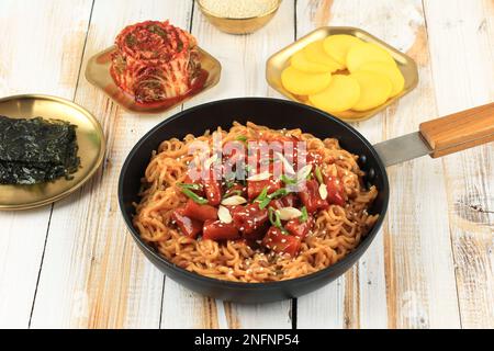 Rabokki, cuisine populaire coréenne de la rue. Tteokbokki Topokki avec Instant Ramyeon, sur une table en bois Banque D'Images