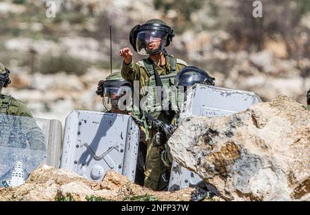 Naplouse, Palestine. 17th févr. 2023. Un soldat israélien défend avec les manifestants palestiniens tandis que d'autres soldats se cachent derrière des boucliers de police lors de la manifestation contre les colonies israéliennes dans le village de Beit Dajan près de la ville de Naplouse en Cisjordanie./ (photo de Nasser Ishtayeh/SOPA Images/Sipa USA) crédit: SIPA USA/Alay Live News Banque D'Images