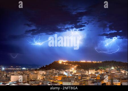 Panorama de Cagliari la nuit avec des éclairs derrière la ville. Tempête de foudre dans le ciel nocturne, au-dessus de la ville. Banque D'Images