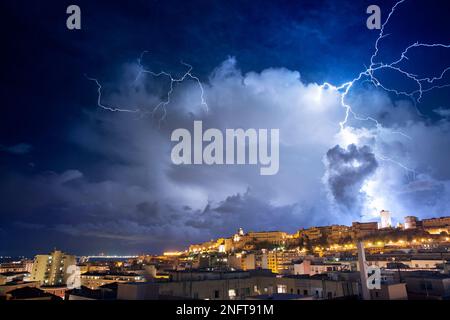 Panorama de Cagliari la nuit avec des éclairs derrière la ville. Tempête de foudre dans le ciel nocturne, au-dessus de la ville. Banque D'Images