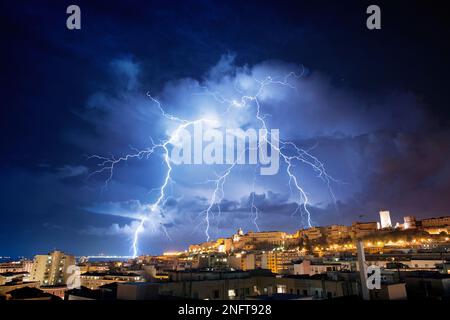 Panorama de Cagliari la nuit avec des éclairs derrière la ville. Tempête de foudre dans le ciel nocturne, au-dessus de la ville. Banque D'Images