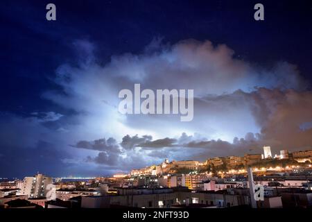 Panorama de Cagliari la nuit avec des éclairs derrière la ville. Tempête de foudre dans le ciel nocturne, au-dessus de la ville. Banque D'Images