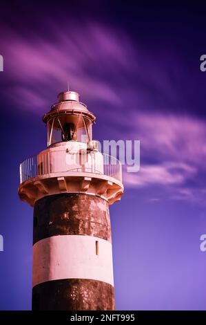 Gros plan du phare au coucher du soleil avec ciel bleu et rose. Longue exposition du phare. Banque D'Images