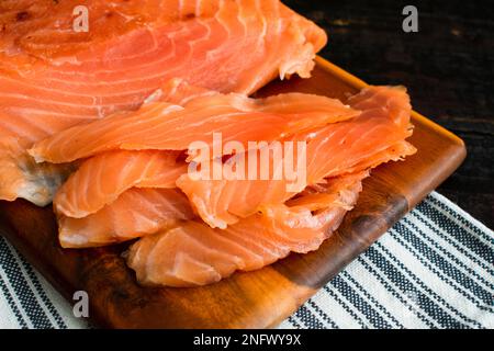 LOX fraîchement tranché sur une planche à découper en bois : vue rapprochée de tranches de saumon salé sur une planche à découper en bois Banque D'Images