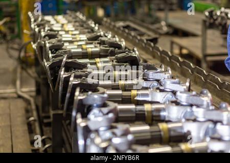 Les arbres à cardans et les transmissions de cardan se déplacent sur le convoyeur pendant le processus de production. Production de composants automobiles pour camions et matériel agricole Banque D'Images