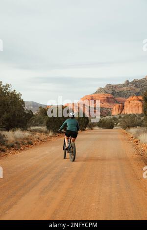 Jeune fille à vélo de montagne sur la route de terre de service de forêt 525 au coucher du soleil dans la nature de Red Rock coconino Sedona Arizona Sud-Ouest des États-Unis. Banque D'Images