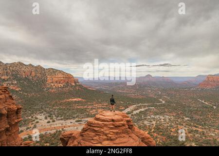 Femme randonneur se tenant sur Bell Rock avec des vues incroyables dans la forêt nationale de coconino à Sedona Arizona USA sur fond de nuages blancs. Banque D'Images