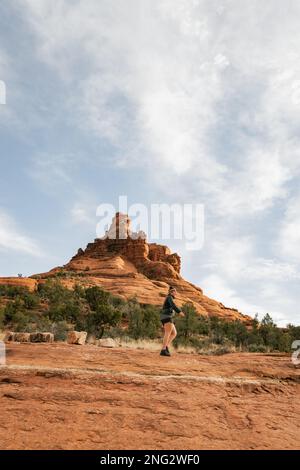 Femme randonneur se tenant sur le sentier Bell Rock dans les formations de roches rouges dans la forêt nationale de coconino à Sedona Arizona USA contre fond de nuages blancs. Banque D'Images