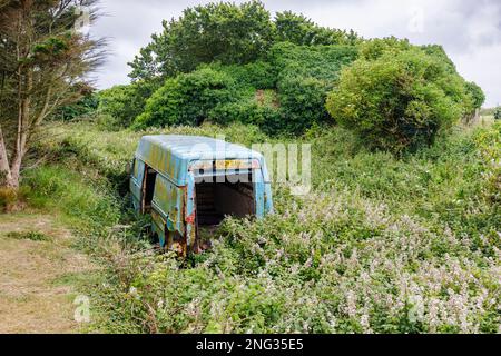 Un minibus bleu abandonné rouillé a été jeté à Marloes, un petit village de la péninsule de Marloes, dans le parc national de la côte de Pembrokeshire, dans l'ouest du pays de Galles Banque D'Images