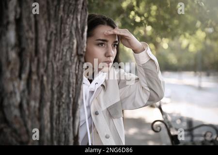 Une jeune femme qui espionne son petit ami dans le parc. Tricherie Banque D'Images