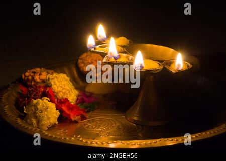 panch pradeep ou lampe à huile à cinq têtes qui brûlent avec une flamme brillante avec des fleurs marigold. ils sont utilisés dans les rituels hindous de puja comme durga , saraswati , Banque D'Images