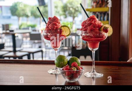 une paire de cocktails daquiri aux fraises fraîchement préparés sur un comptoir en bois Banque D'Images