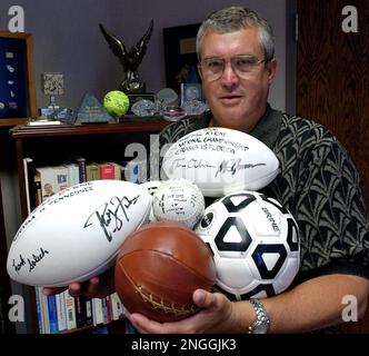Nebraska athletic director Bill Byrne stands in his office holding various balls autographed by Nebraska's successful coaches on June 18, 2001, in Lincoln, Nebraska. (AP Photo/Nati Harnik)