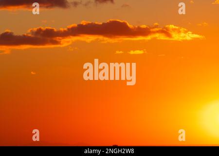 Photo d'arrière-plan du coucher du soleil Ciel partiellement nuageux au coucher du soleil. Ciel orange. Banque D'Images