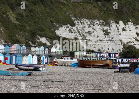Sur la plage dans le village de pêcheurs de Beer à Devon, Angleterre. La plage de galets abrite des cabanes de plage et des bateaux de pêche. Banque D'Images