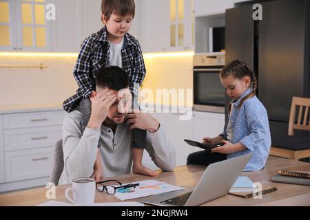 Homme submergé combinant le rôle parental et le travail à la maison Banque D'Images